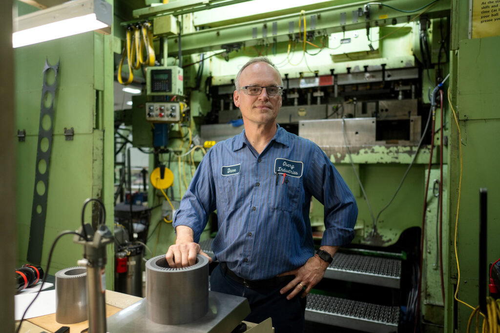 A skilled Oberg Industries technician in front of a stamping press, showcasing expertise in precision manufacturing for power generation laminations