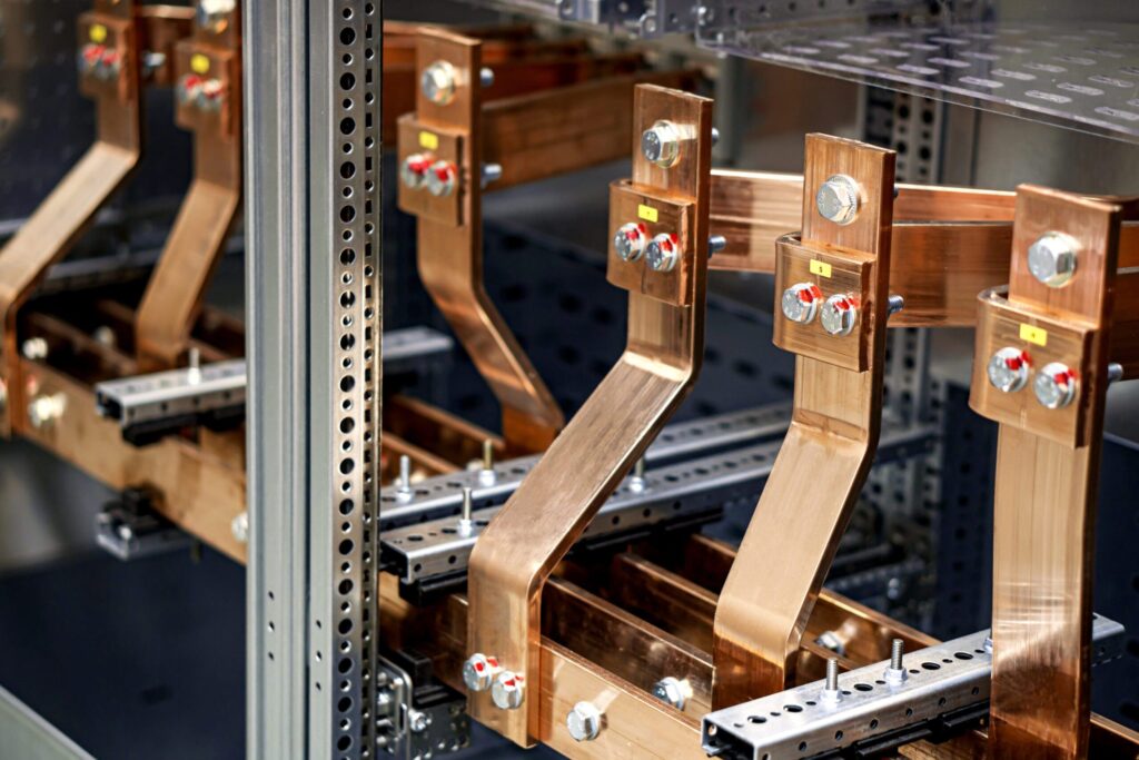 A set of industrial-grade copper busbars installed in an electrical panel, designed for efficient power distribution and conductivity in high-current applications.